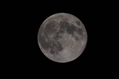 Ay, dingin güzelliğiyle gece gökyüzünü aydınlatıyor.