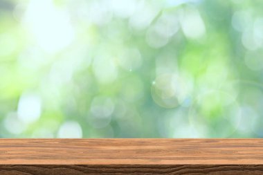 Görünürde ürün tanıtımı ve reklamcılığı için soyut, bulanık yeşil bokeh ve kahverengi ahşap masa üstü perspektifi tezgahı