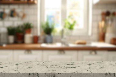 İskandinav mutfağındaki boş ve temiz mermer yemek masası. Ahşap mobilyaların üzerinde mavi çekmeceleri olan modern monokrom iç mekan. Masa giysisi ve çiçekli vazolar.