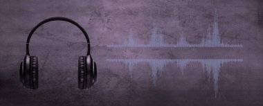 Arka fonda kulaklık ve dalga boyu olan profesyonel mikrofon. Podcast veya kayıt stüdyosu arka planı