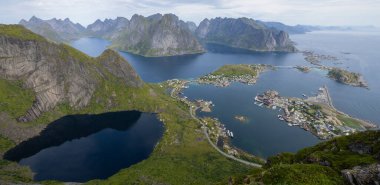 Günbatımı sersemletici dağlara ve Norveç 'in Lofoten adalarındaki Reine köyüne Reinebringen sırtından günbatımı panoramik manzara