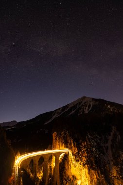 Bernina Ekspres treni üzerinde yıldızlar, Filisur, İsviçre. Landwasser viadukt. Samanyolu galaksisinin merkezi.