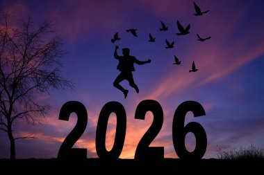 Mutlu yıllar - Manzara arka plan panoraması 2026 - Dağların siyah silueti ve insanın yıl tutuşu ile nefes kesici manzara, gün doğumunda