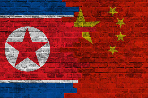 Grunge country flag illustration cracked concrete background China vs North korea Political or economic conflict