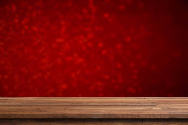 Önplanda boş ahşap masa. Ürün yerleştirme için arka planda kahverengi ya da kırmızı renkli duvar kağıdı var. Lüks konsept için kırmızı arkaplanı olan boş kahverengi ahşap masa.