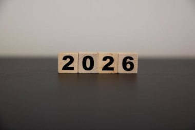 Güneş tarafından vurgulanan doğal ahşap küp üzerine 2026, Yeni Yıl 2026 'yı karşılama kavramı