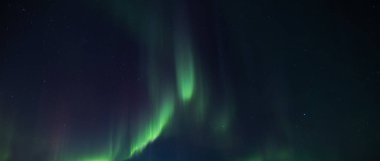 Karlı köknar ağaçları ve yıldızlı gökyüzünde inanılmaz kuzey ışıkları olan peri kışı dağları. Kutup ışıklarıyla Noel gecesi manzarası. Aurora Borealis