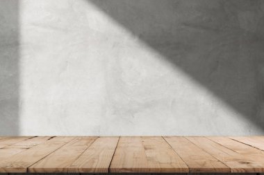 Soyut beyaz beton duvarda, güneş ışığı gölgesi yansıyan boş ahşap masa üstü. Montaj ürün tasarım modeli için