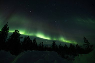 Kuzey Işıkları 'nın büyüleyici cazibesine kapıl. Canlı gökyüzü renkleri gece gökyüzünde dans ediyor,