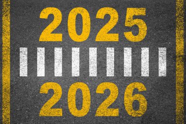 Yeni yıl 2026 ya da yeni yıl konsepti. Metin 2025, 2026, 2027, 2028 gün batımında asfalt yolun ortasında yazılmış. Planlama, hedef, meydan okuma, yeni yıl çözümü kavramı.