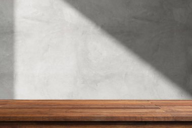 Beyaz duvarlı, ahşap bir masa ve pencereden süzülen güneş ışığı..