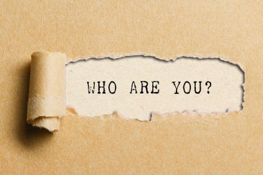 Kimsiniz siz? Yırtık kağıt altında yazılmış soru.