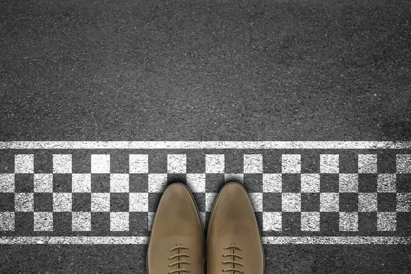 İş adamı bitiş çizgisiyle asfalt beton zeminde duruyor. Başarılı bir kavram..