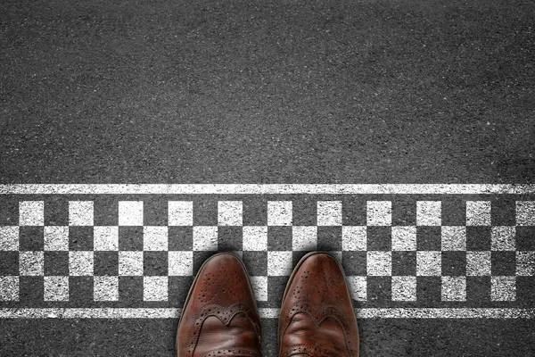 İş adamı bitiş çizgisiyle asfalt beton zeminde duruyor. Başarılı bir kavram..