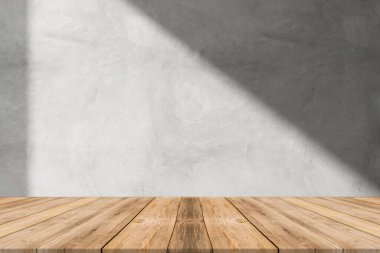 Beyaz duvarlı, ahşap bir masa ve pencereden süzülen güneş ışığı..