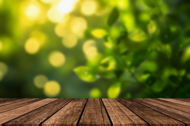 Eski ahşap masa üstünün boş, ahşap dokusu, çözünmüş güneş ışığıyla yeşil parka karşı bulanık, arka planda bulanık yapraklar. Modellemeyi göster, ürününüzü kurgulayın, anahtar görsel düzenini tasarlayın