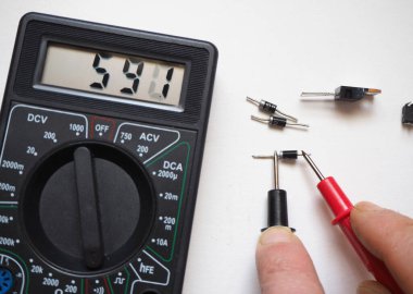 Semiconductor electronic components. Diode test with digital multi meter on a white. clipart