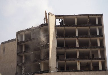 İnşaat makinesi yüksek bina yıkımında çalışıyor.