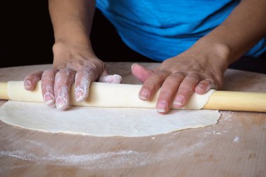 Evde ahşap hamurla yuvarlanan hamurlar.