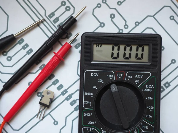 Electric-Electronic Engineering concept with drawing paper and digital multimeter.