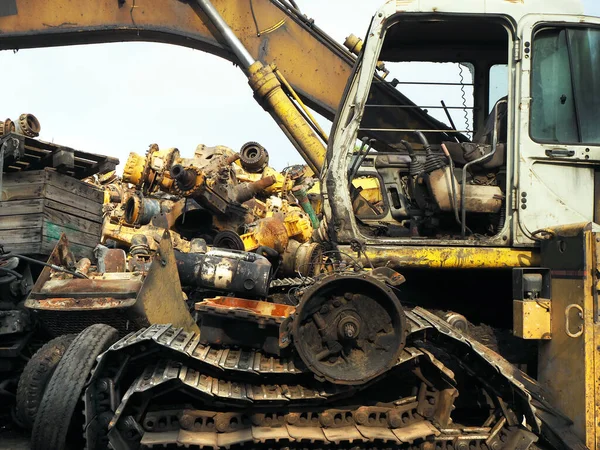 Hurdalıkta makine parçaları ve hurda buldozer. Kullanılamaz durumda inşaat ekipmanları ve yedek parça veya geri dönüşüm için demir malzemeler.