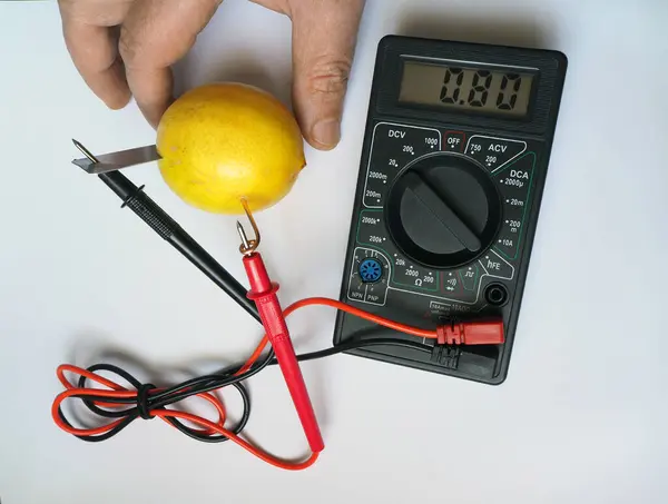 Lemon and electricity experiment. Generating and measuring electricity from lemon. Electrical voltage at millivolts levels. Bio battery.