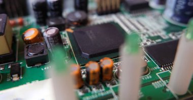 Elektronik devre kartının merkezi işlemcisini kapat. Yarı iletken mikroçip üzerine odaklanmış.