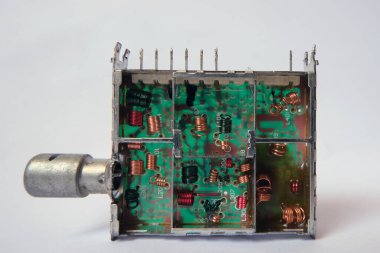 TV tuner box with air-core copper inductors on printed circuit board. Selected focus.        clipart