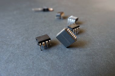 Karanlık bir yüzeyde çeşitli entegre devreler. Sanayi için yarı iletken elektronik bileşenler.