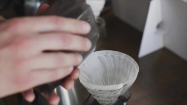 Barista pourover yapmak için beyaz bir filtreye kahve doldurur.