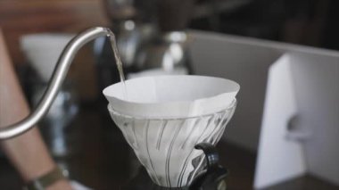 Barista kahve filtresine su dolduruyor.