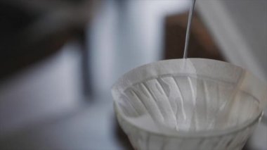 Barista kahve filtresine su dolduruyor.