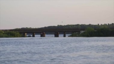 Köprü, huzur dolu gölün üzerinden geçen bir yol.