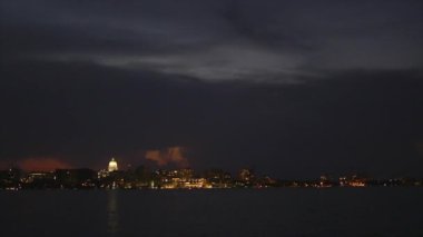 Madison Wisconsin, gün batımında bir gölden görülen fırtına bulutlarıyla gökyüzü çizgisi.