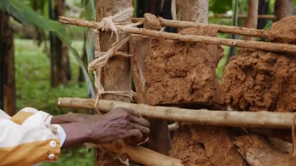 Hombre Africano Construyendo Una Casa Con Palos Rocas Rojas Pueblo — Vídeos de Stock