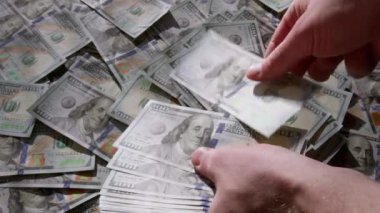 Erkek ellerinin yakın plan para geçmişindeki 100 dolarlık banknotları sayması. Bir iş adamı nakit sayıyor. Yatırım, para değişimi, rüşvet veya yolsuzluk kavramı.