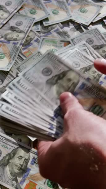 バーティカルビデオ お金の背景に100ドルの紙幣を数える男性の手の閉鎖 ビジネスマンが現金を数えている マネー交換 賄賂の概念 — ストック動画