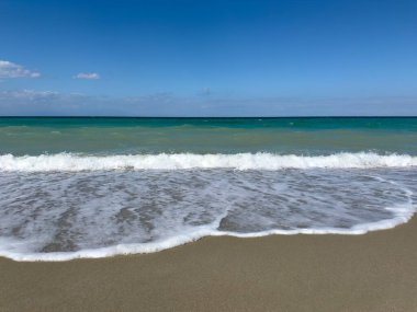 Yunanistan 'daki deniz. Ege Denizi 'nin kumlu sahilinde küçük dalgalar.