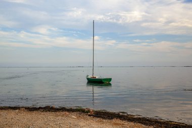 Deniz kıyısında küçük bir yelkenli.