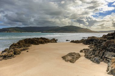 Las Vacas plajı, Galiçya, İspanya 'dan bulutlarla kaplı yeşil dağların manzarası