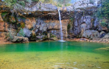 İspanya 'nın Campdevnol kentindeki 7 Gorg' un yürüyüş rotasında zümrüt suları olan doğal bir havuzda şelale.