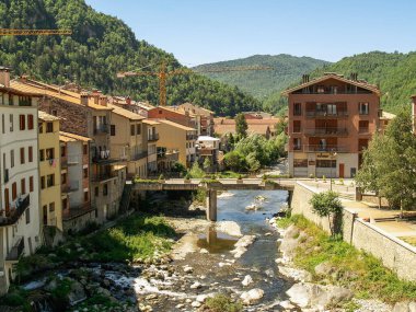 Nehir geçidi ve arkasında dağlar olan Camprodon manzarası.