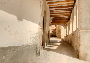 İspanya 'nın Tarragona, Miravet köyünde güneş ışığıyla aydınlatılan pencereleri ve tahta kirişleri olan geçit.