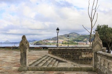 Meydandan deniz manzarası inanılmaz dağların manzarası ve bulutlarla kaplı Castro Urdiales kasabası. Galiçya, İspanya.