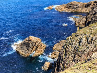 Vilano Burnu kıyılarının ayrıntıları, yoğun mavi denizin olduğu bir günde sarp kayalıklarla dolu. Galiçya, İspanya.