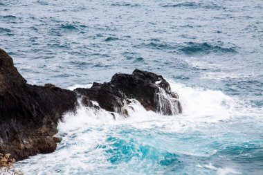 Dalgaların köpüğüyle kaplı denizdeki kayalar..