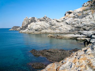 Kayalar, Cap de Creus Doğal Parkı, Katalonya, İspanya 'daki derin mavi denizle çelişiyor.