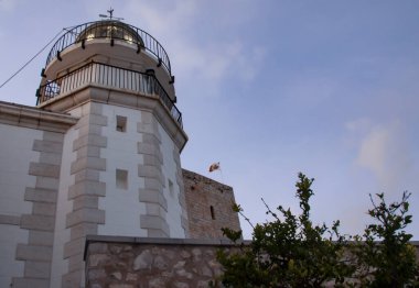 Detail of the Peniscola Lighthouse, at the top of the tower is the lantern, which is surrounded by a small balcony with a metal railing. clipart