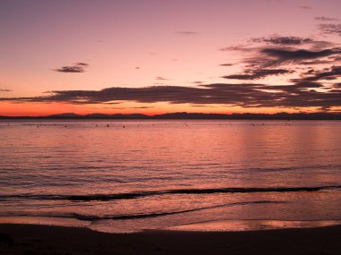 Günün son kırmızı ışıkları, deniz kıyısında görüldü..