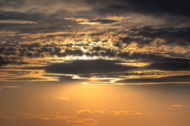 Gökyüzündeki zıtlık, siyah bulutların altındaki altın ışıktır. Karanlık ve aydınlık arasındaki şiirsel dans